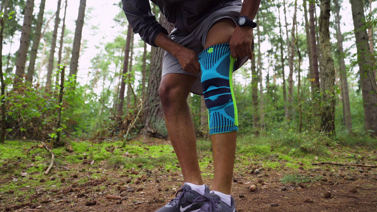 Runner wearing a Bauerfeind sports knee support on a trail run